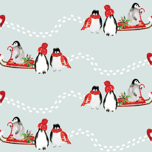 Penguins in a sled with red hats and scarfs