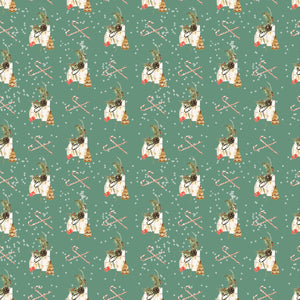 Green Christmas wrapping paper with white houses, pine tree branches and cones with white dots and candy canes in the background