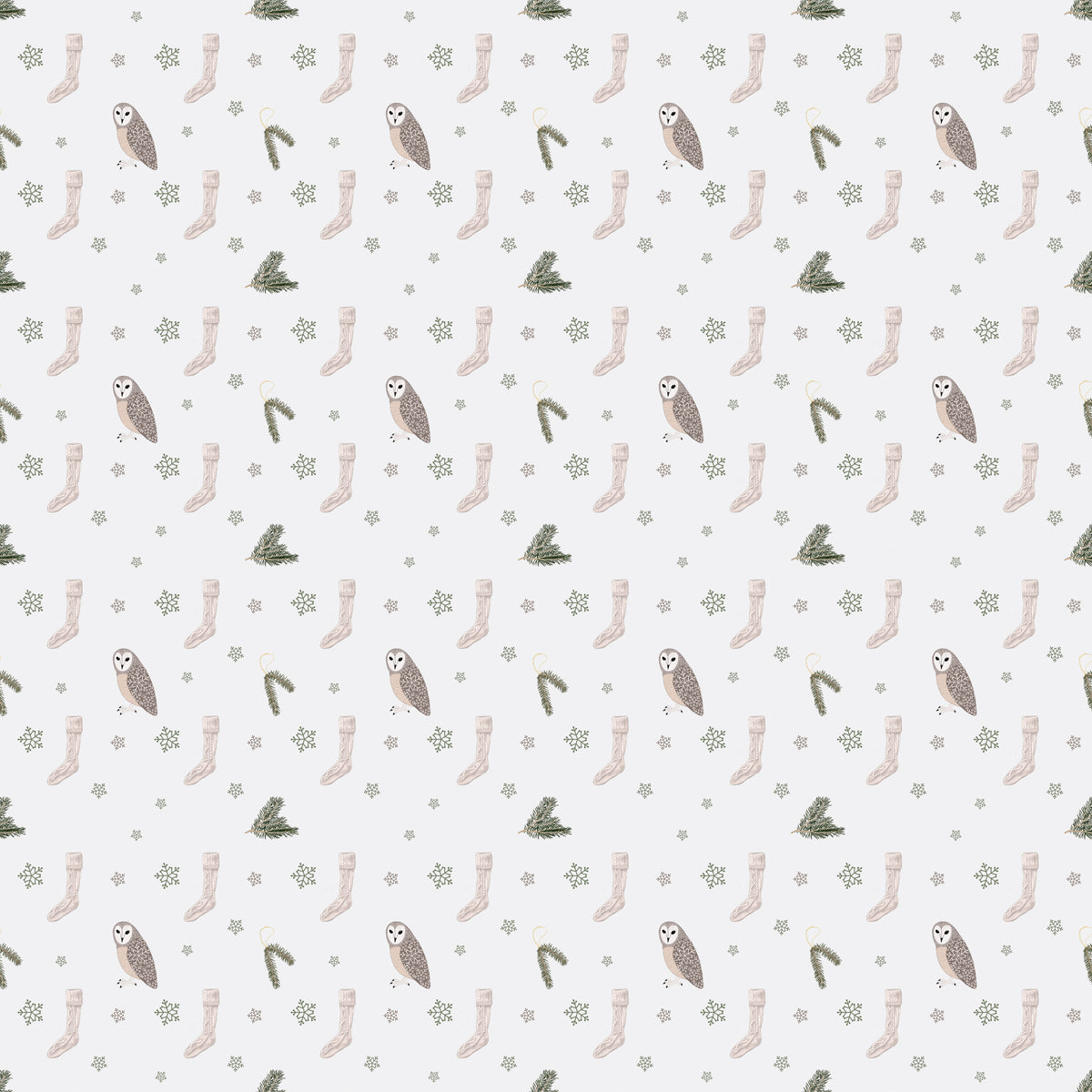 White wrapping paper with an owl, beige socks, pine tree branches and green snowflakes